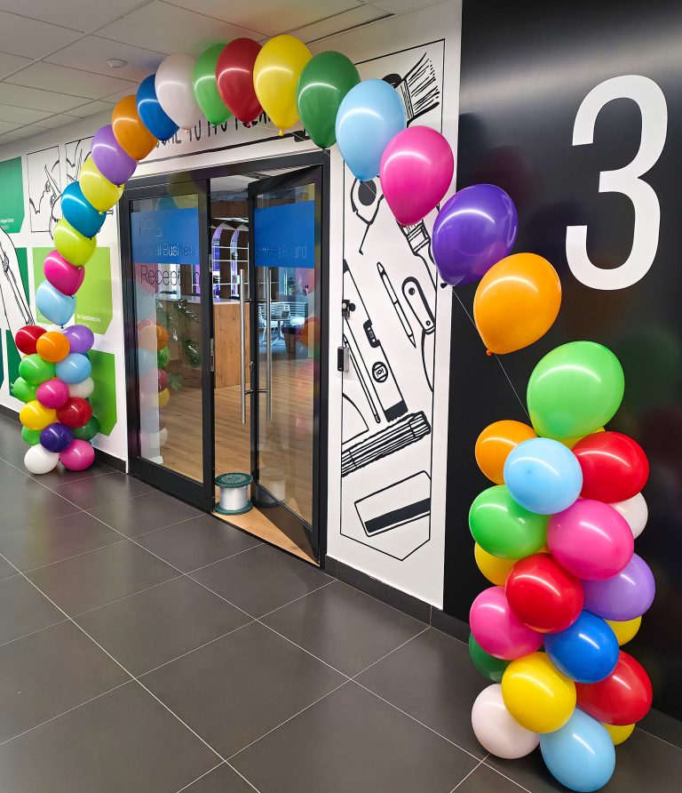 Urodzinowa dekoracja wejścia do biur firmy przy pomocy balonów z helem