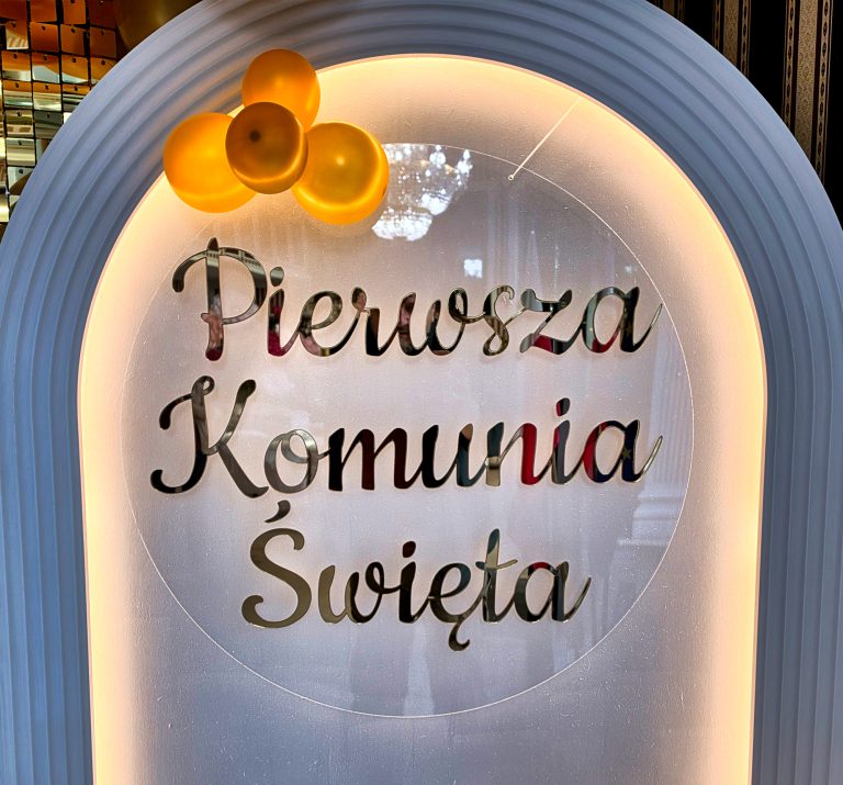 Napis na ściance z balonów o treści Pierwsza Komunia Święta