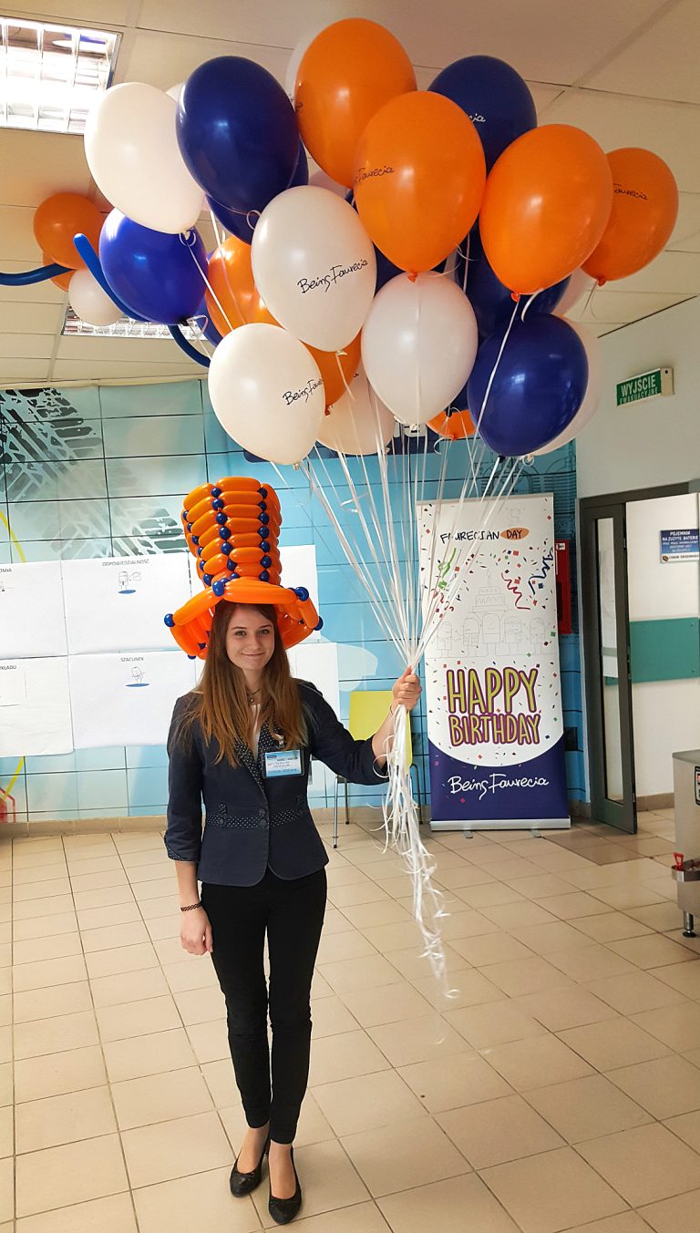 Hostessa z pękiem balonów helowych czeka na dzieci aby rozdać im balony
