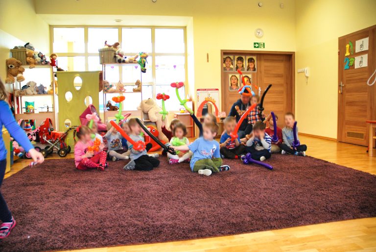 Przedszkolaki pozują do zdjęcia z balonowymi figurkami