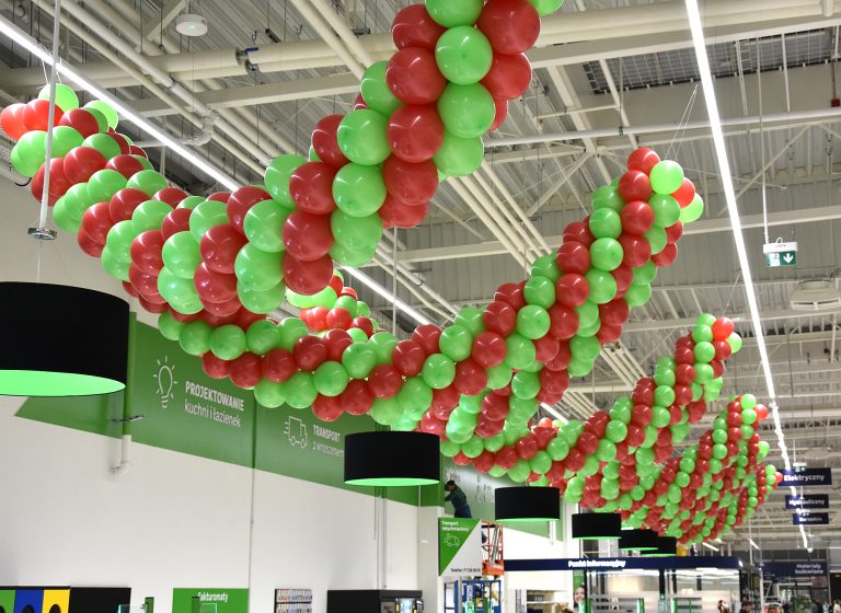 Girlandy balonowe nad kasami jako dekoracja urodzinowa w markecie budowlanym