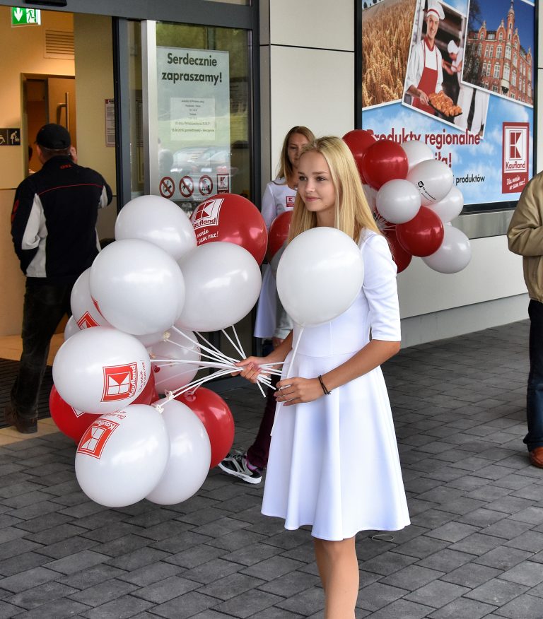 Hostessa z balonami z nadrukiem założonymi na patyczki