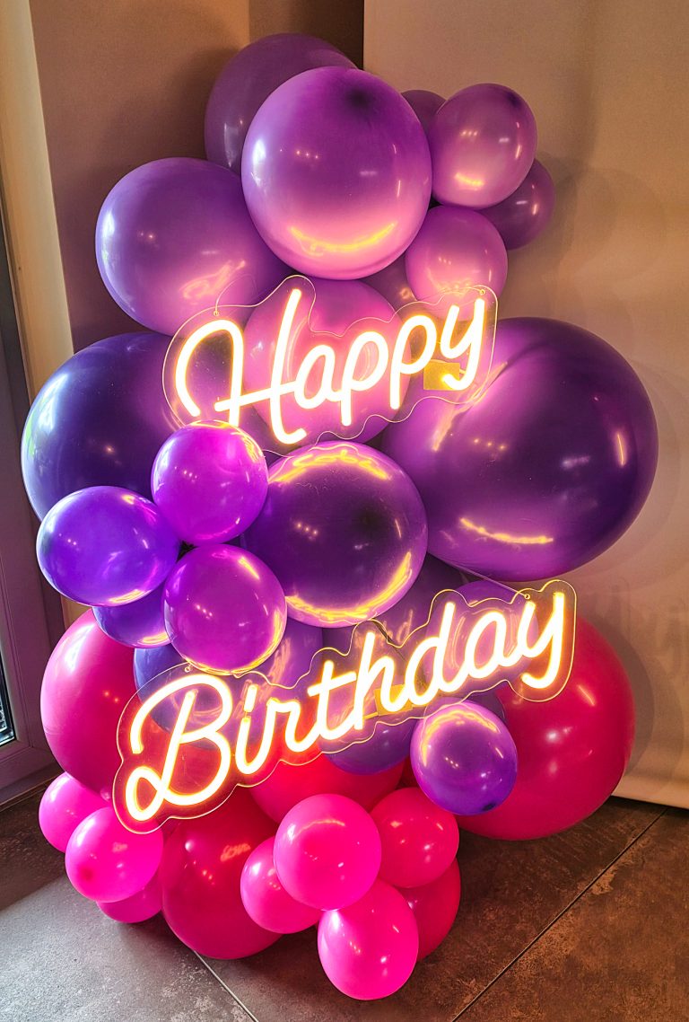 Neon o treści Happy Birthday jako element balonowej ścianki urodzinowej