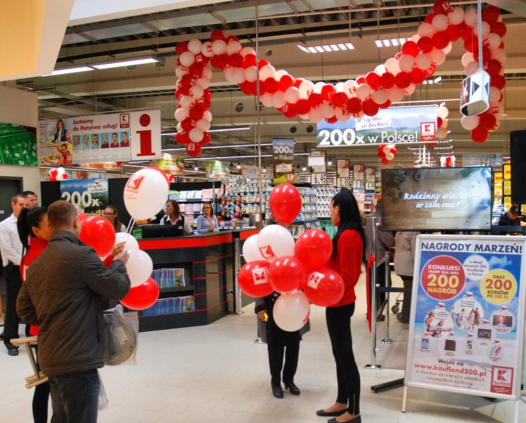 Hostessy rozdają balony z nadrukiem na patyczkach w kileckim Kauflandzie
