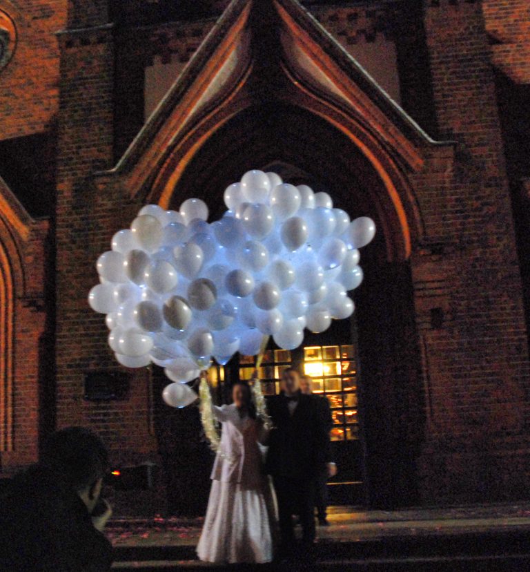 Puszczanie balonów z helem po ślubie pod kościołem
