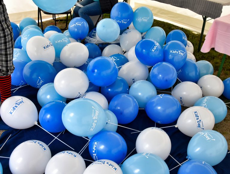 Balony z nadrukiem założone na patyczki z okazji Dnia Dziecka