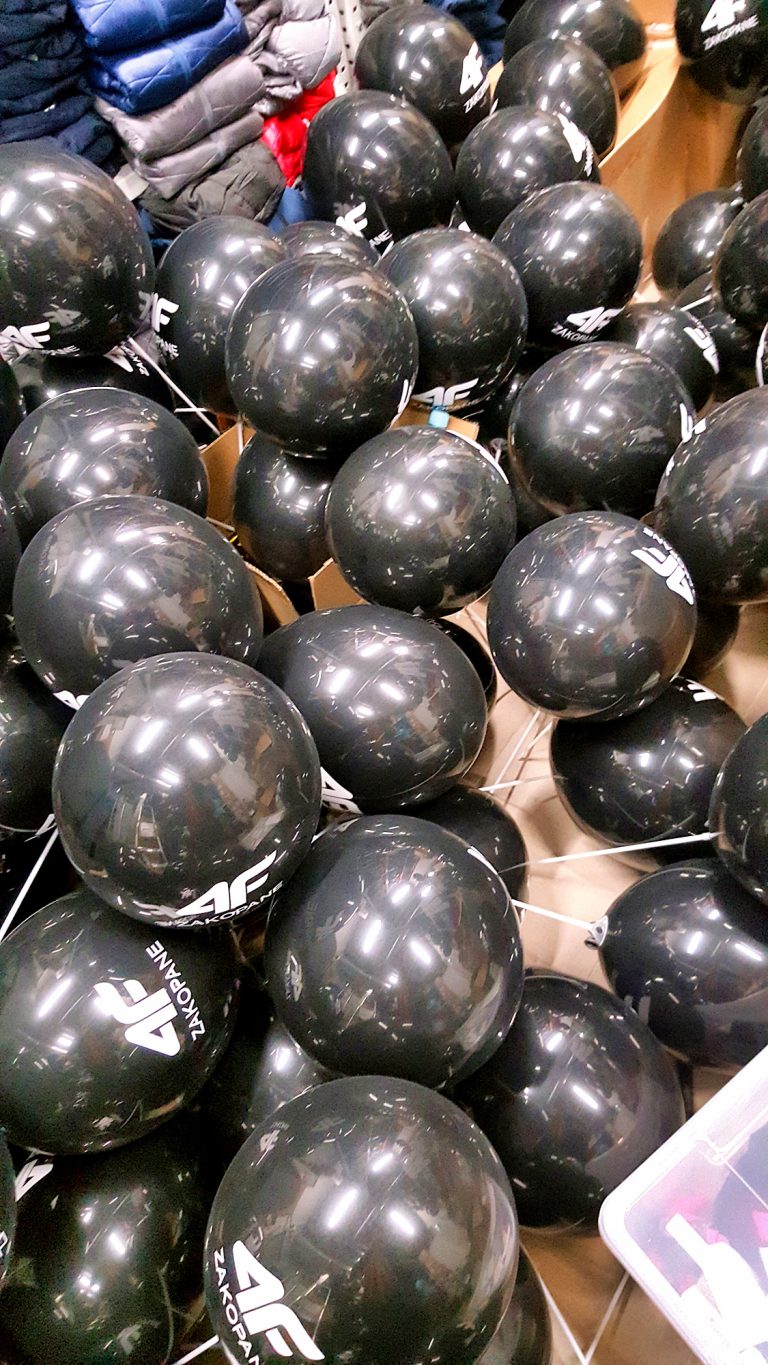 Balony z logo 4F napełnione powietrzem i założone na patyczki
