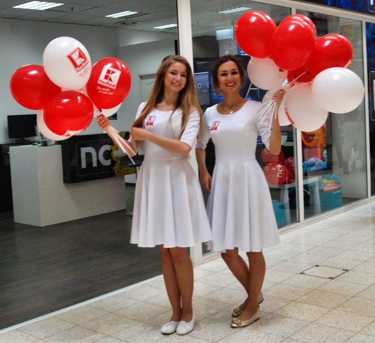 Hostessy rozdają balony z nadrukiem założona na patyczki