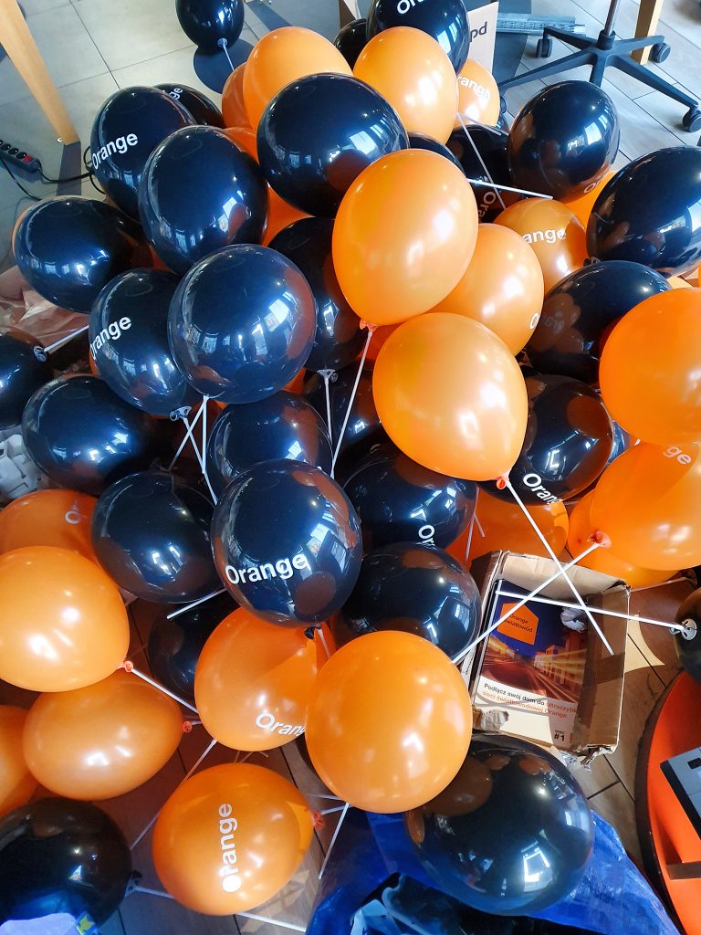 Balony z logo założone na patyczki jako atrakcja na otwarcie salonu firmy Orange