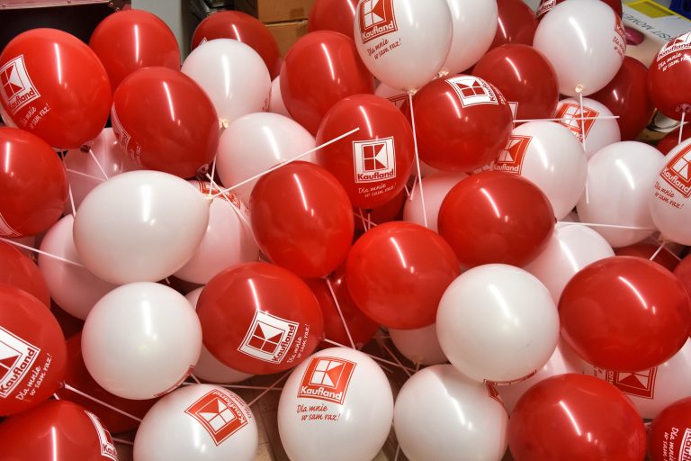 Balony z nadrukiem logo Kaufland założone na patyczki