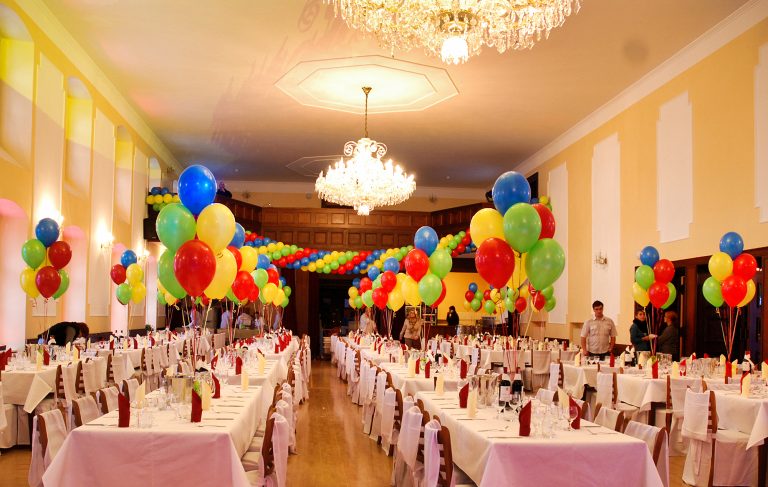 Kolorowe bukiety balonów z helem na stołach