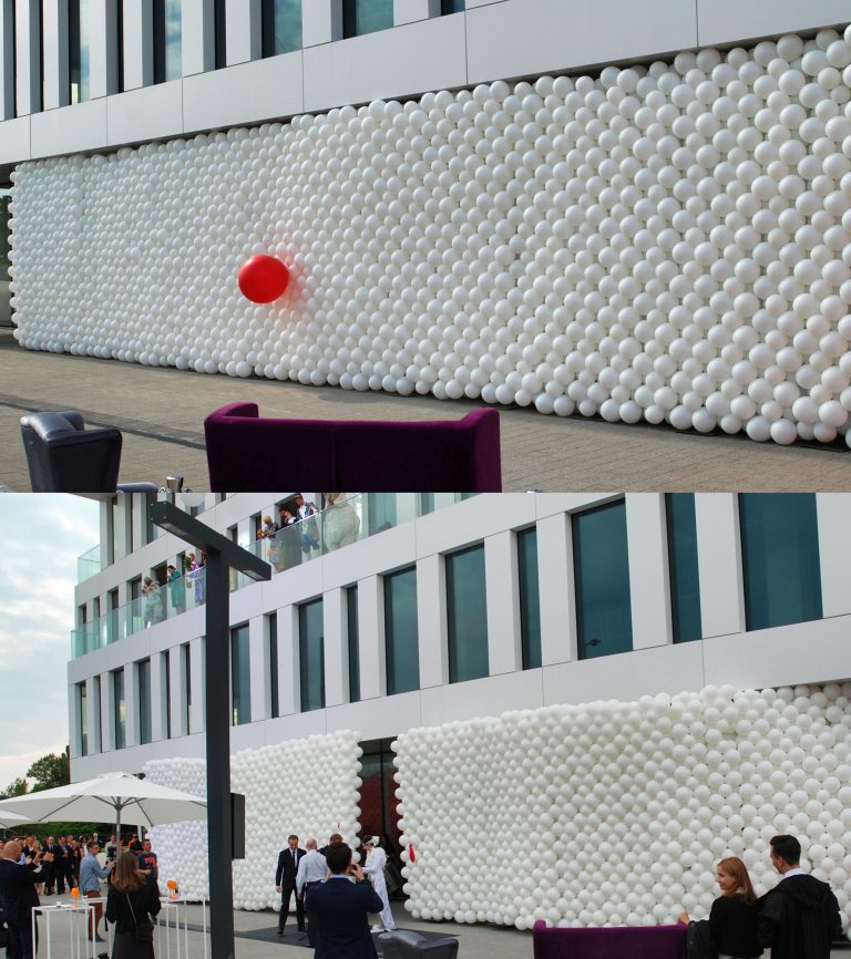 Otwierająca się ściana z balonów jako dekoracja na otwarcie nowego biurowca
