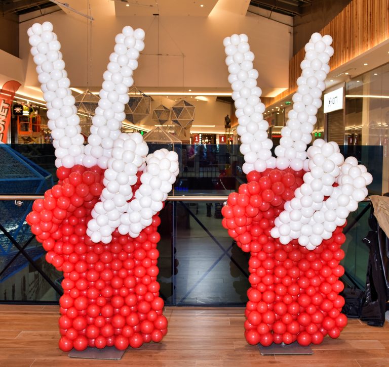 Dłonie z balonów ułożone w symbol zwycięstwa jako dekoracja na otwarcie sklepu